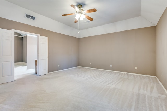 unfurnished bedroom with ceiling fan, light carpet, and a tray ceiling