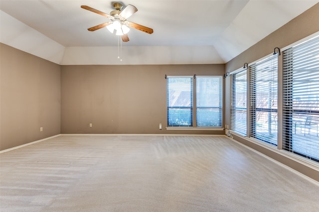 carpeted spare room with ceiling fan and lofted ceiling