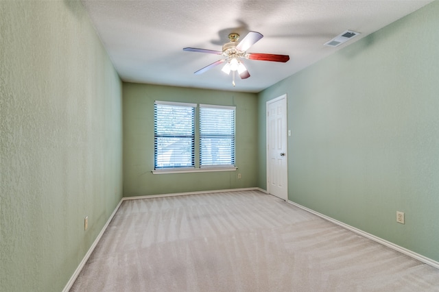 carpeted spare room with ceiling fan and a textured ceiling