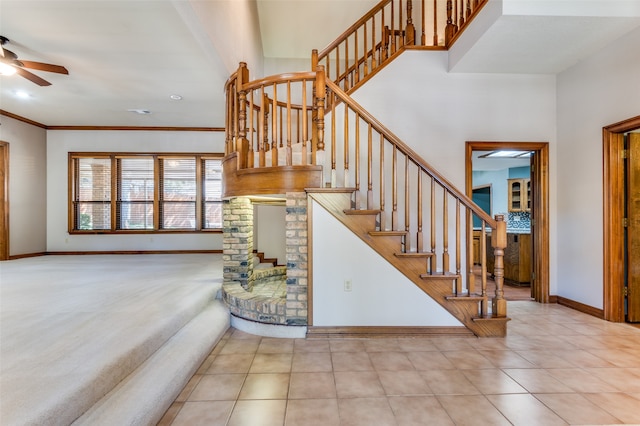 staircase with crown molding, tile patterned flooring, and ceiling fan