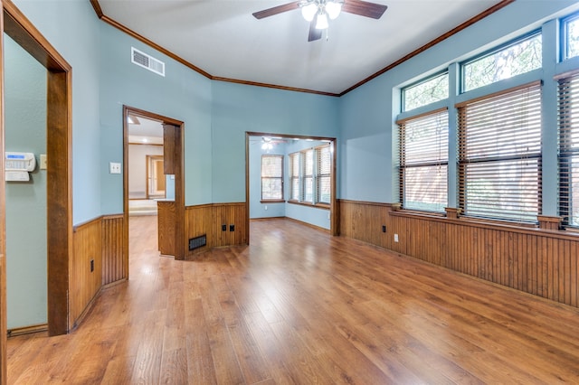 empty room featuring light hardwood / wood-style flooring, ceiling fan, and ornamental molding