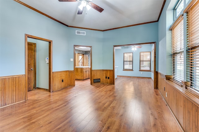 spare room featuring light hardwood / wood-style flooring, plenty of natural light, ornamental molding, and ceiling fan