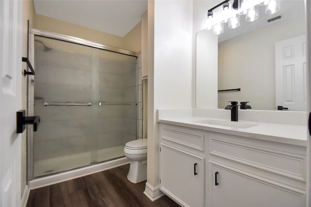 bathroom featuring walk in shower, vanity, hardwood / wood-style floors, and toilet