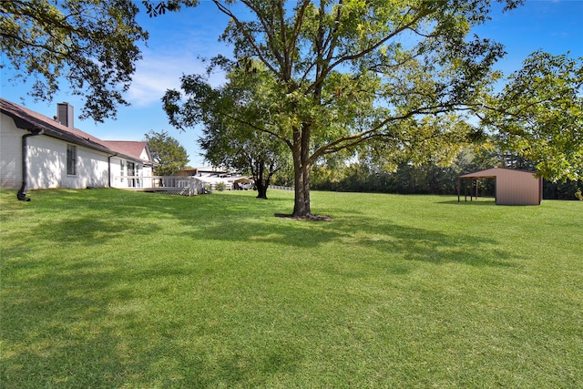 view of yard featuring a deck and a storage shed