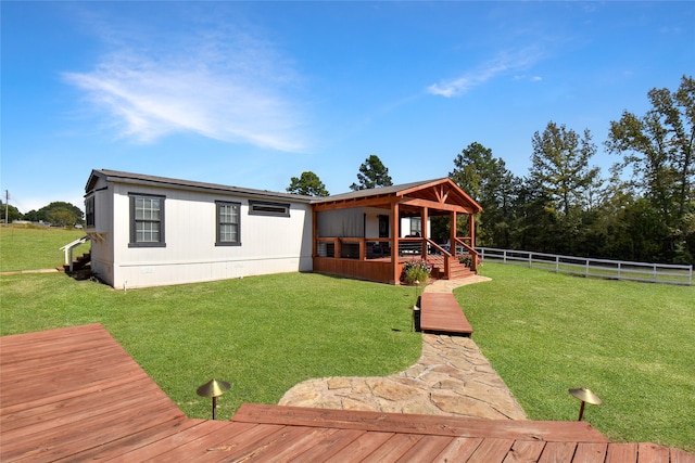 view of front of property featuring a front lawn and a wooden deck