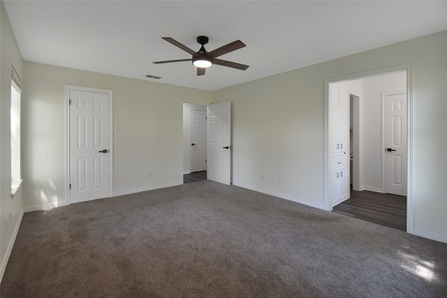 unfurnished bedroom with dark colored carpet and ceiling fan