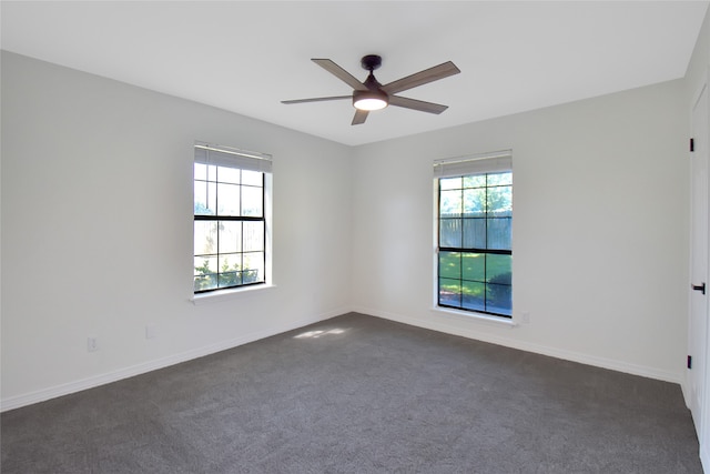 unfurnished room with dark colored carpet and ceiling fan