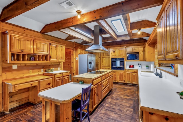 kitchen with island range hood, a kitchen island, dark wood-type flooring, black appliances, and a skylight