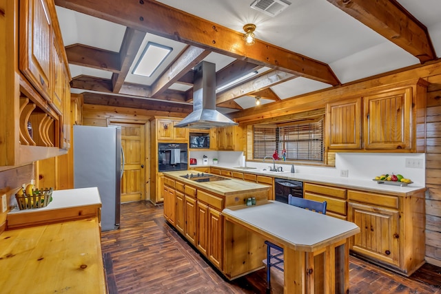 kitchen with black appliances, island range hood, visible vents, and a center island