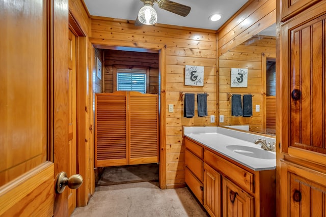 bathroom with vanity, ceiling fan, and wooden walls