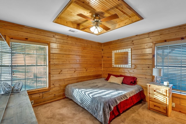 bedroom with wooden walls, light colored carpet, wooden ceiling, and ceiling fan