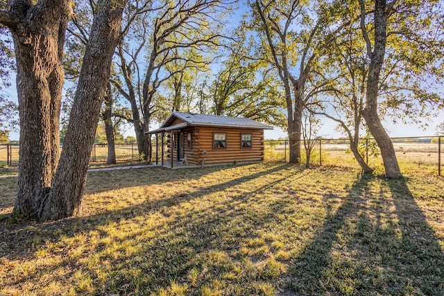 view of yard featuring a rural view, fence, and an outbuilding