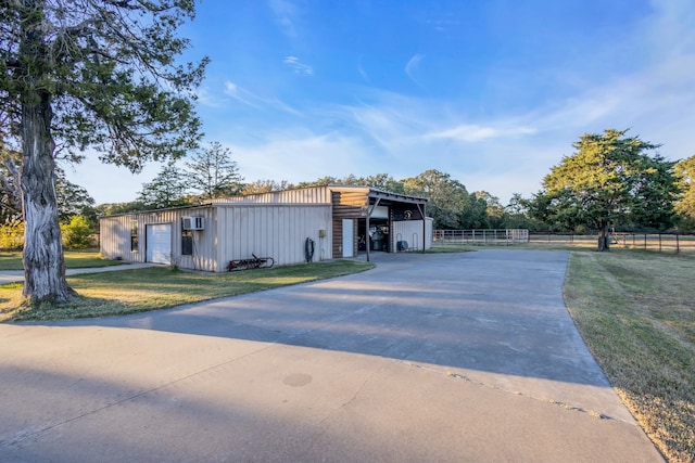 view of front of property with a garage, a front yard, fence, and an outbuilding