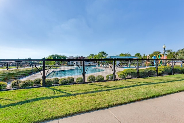 view of swimming pool with a yard