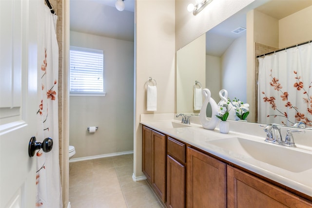 bathroom with tile patterned flooring, vanity, and toilet