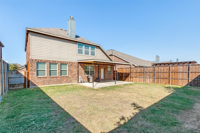 rear view of house featuring a lawn and a patio