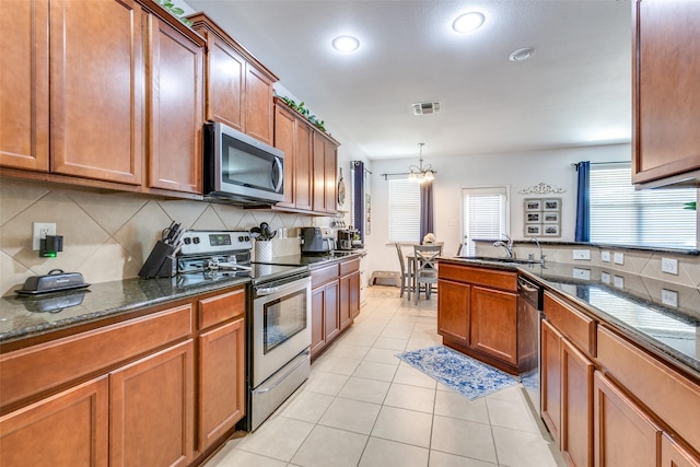 kitchen with backsplash, a notable chandelier, sink, and appliances with stainless steel finishes