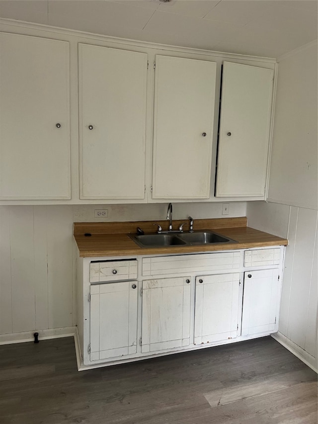 kitchen with dark wood-type flooring, sink, and white cabinetry