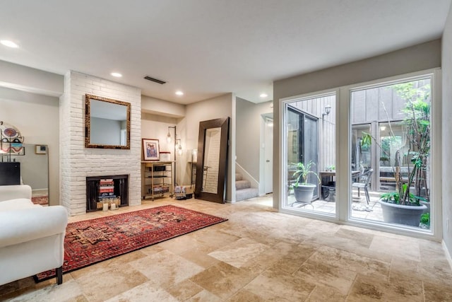 living room featuring recessed lighting, a fireplace, baseboards, stairs, and stone finish flooring