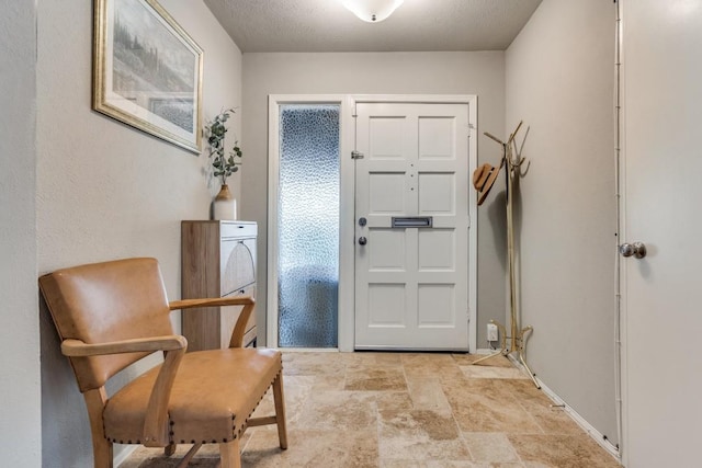 foyer featuring stone finish floor and baseboards