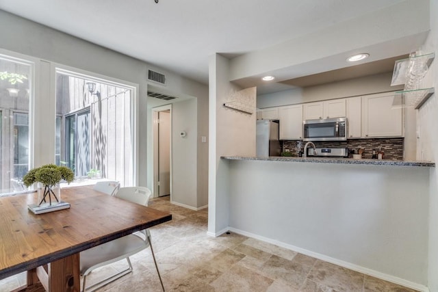 kitchen with visible vents, appliances with stainless steel finishes, white cabinetry, and tasteful backsplash