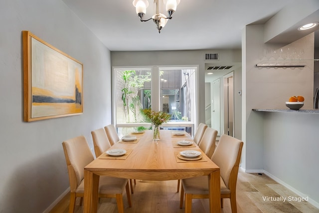 dining space featuring an inviting chandelier, visible vents, and baseboards