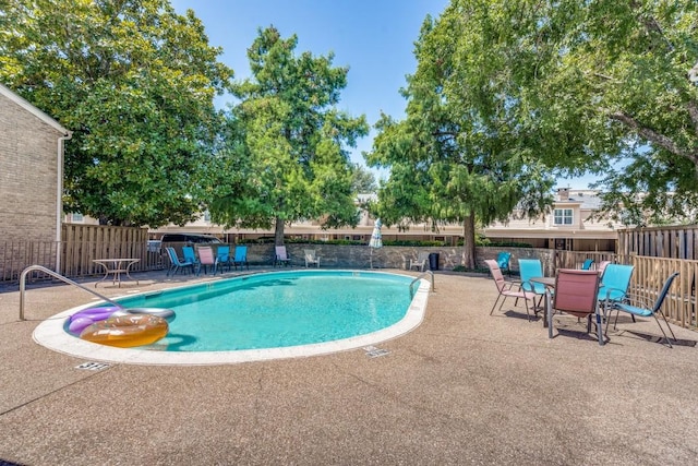 pool with outdoor dining area, a patio area, and fence