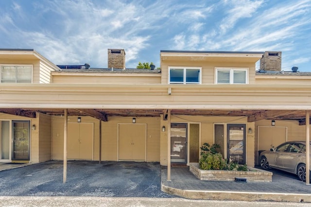 view of front of property with covered parking and a chimney