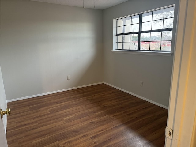 unfurnished room featuring dark wood-type flooring