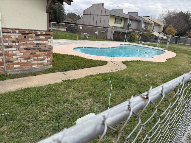 view of pool featuring a lawn and a patio