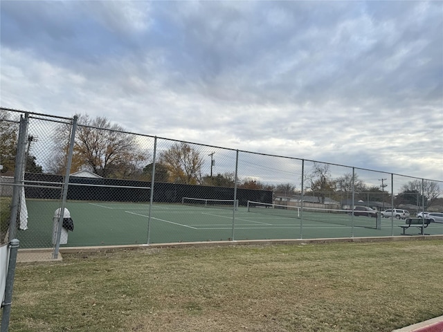 view of sport court with a yard