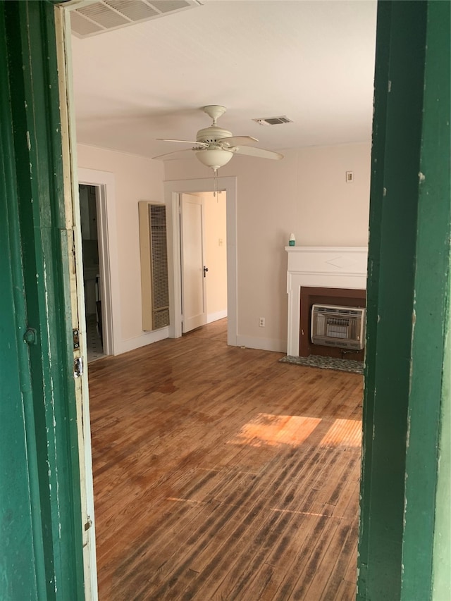 unfurnished living room featuring ceiling fan, dark hardwood / wood-style floors, and a wall mounted air conditioner