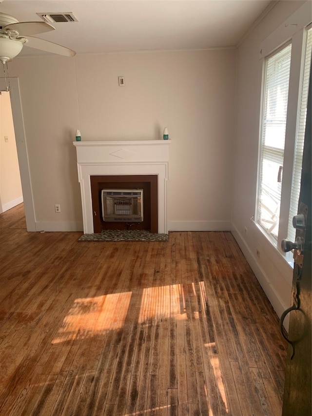 unfurnished living room with heating unit, ceiling fan, and dark hardwood / wood-style floors