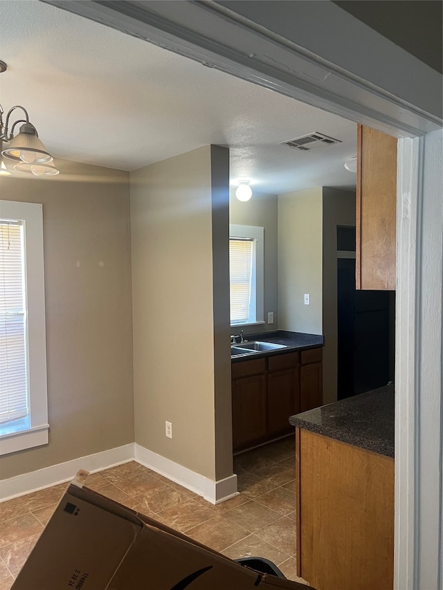 interior space featuring plenty of natural light, light tile patterned floors, and sink