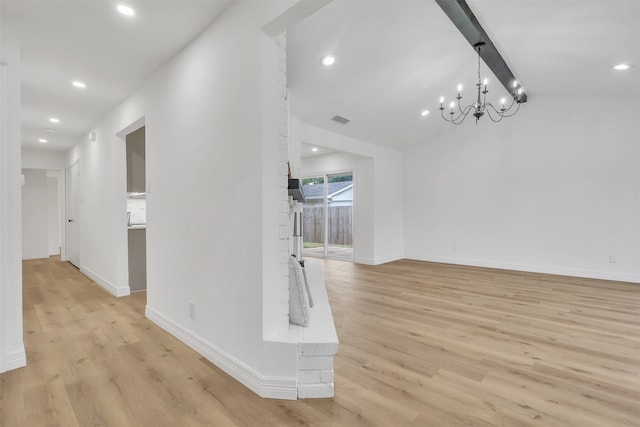 unfurnished living room with a chandelier, light hardwood / wood-style floors, and lofted ceiling with beams