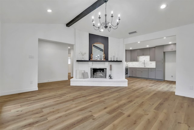 unfurnished living room featuring vaulted ceiling with beams, light hardwood / wood-style flooring, and sink