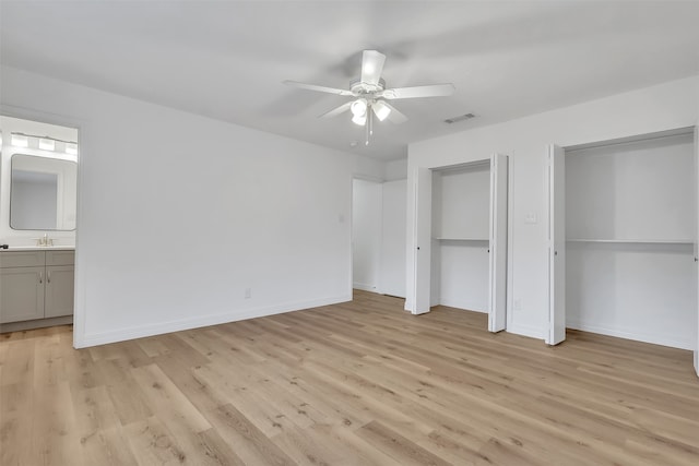 unfurnished bedroom featuring ceiling fan, sink, light hardwood / wood-style flooring, and ensuite bathroom