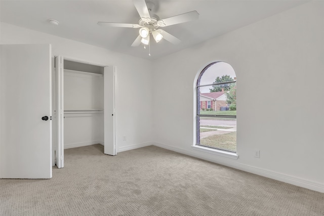 unfurnished bedroom featuring ceiling fan, a closet, and light carpet