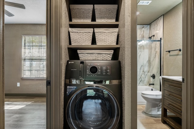 laundry area with light wood-type flooring and washer / dryer