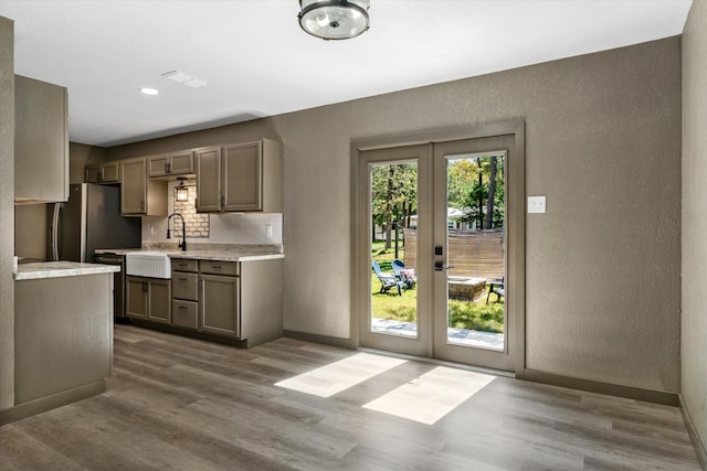 kitchen featuring french doors, wood-type flooring, tasteful backsplash, and sink