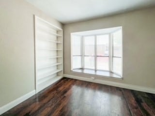 spare room with dark hardwood / wood-style flooring