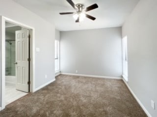 unfurnished room with ceiling fan and carpet