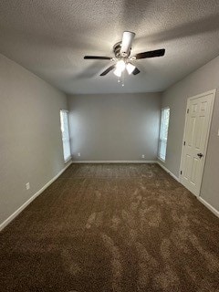 spare room featuring dark colored carpet, ceiling fan, and a textured ceiling