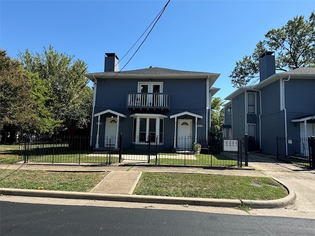 view of front of home featuring a balcony and a front yard