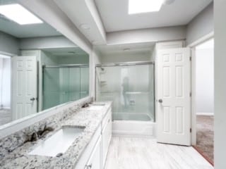 bathroom with vanity and combined bath / shower with glass door