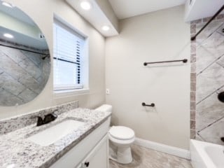 full bathroom featuring tile patterned flooring, vanity, toilet, and tiled shower / bath