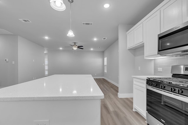 kitchen featuring white cabinetry, stainless steel appliances, ceiling fan, light hardwood / wood-style flooring, and decorative light fixtures