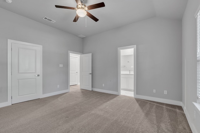 unfurnished bedroom with ceiling fan, light colored carpet, vaulted ceiling, and ensuite bathroom