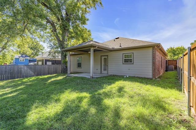 back of house featuring a lawn, a patio, and central air condition unit