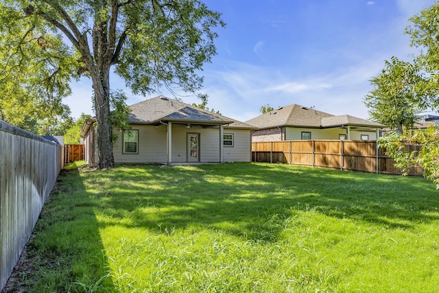 rear view of property featuring a yard